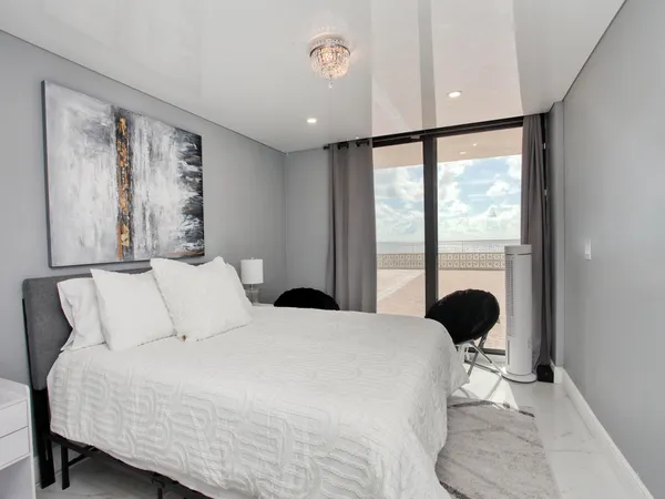 a bedroom with a large bed and a large window