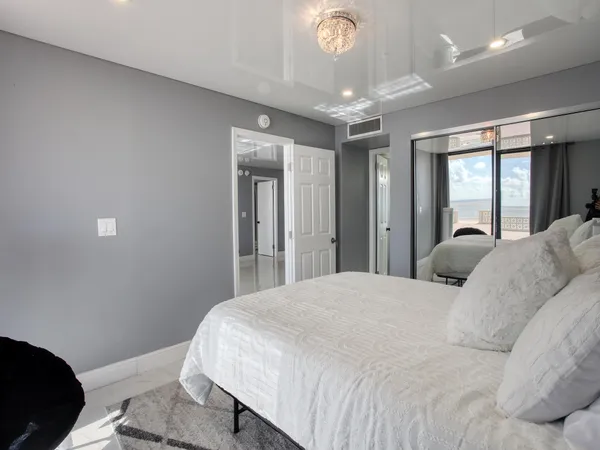 a bedroom with a bed and a large mirror