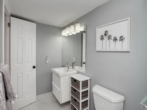 a spacious bathroom with a toilet sink and a mirror