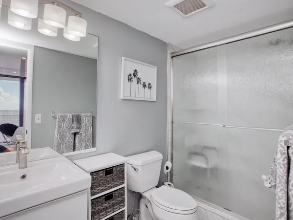 a bathroom with a sink a toilet and shower