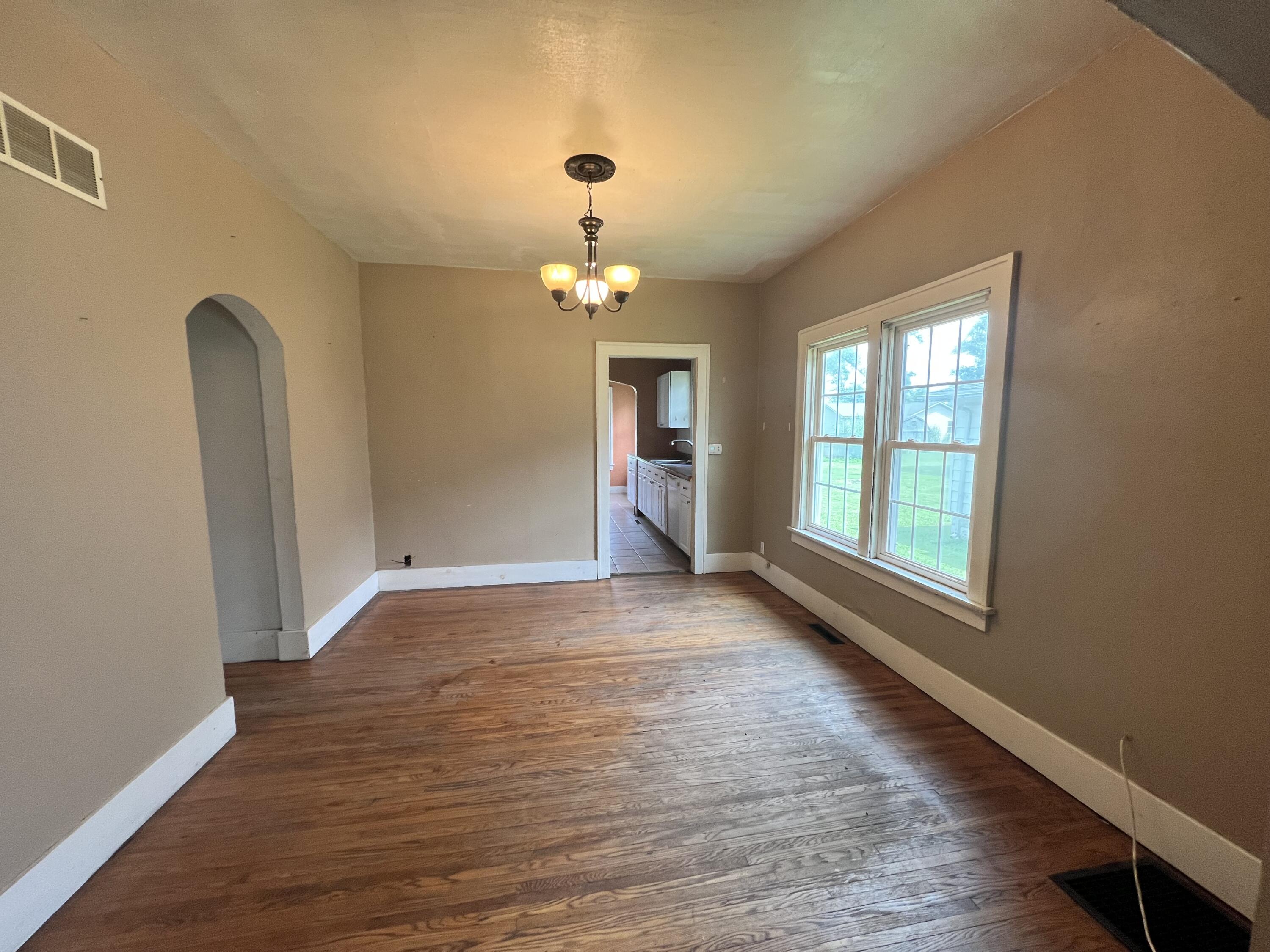 702 East Elm Street Rensselaer, IN 47978 - Photo 8 of 22 a view of an empty room with wooden floor and a window