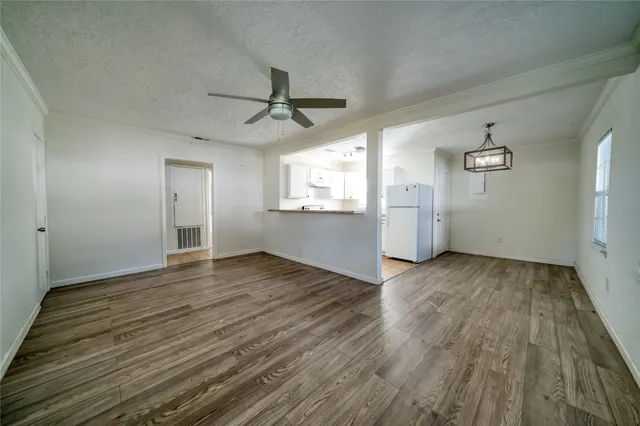 a view of empty room with wooden floor and window