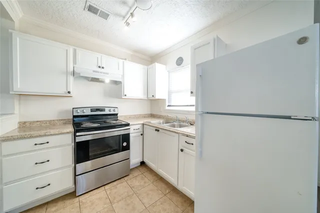 a kitchen with stainless steel appliances white cabinets and white appliances