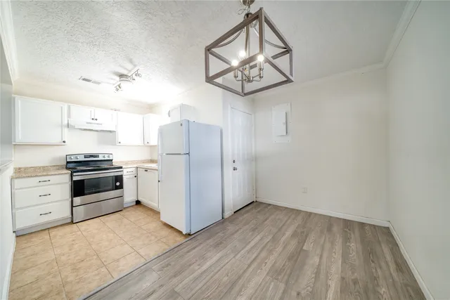 a kitchen with cabinets wooden floor and stainless steel appliances