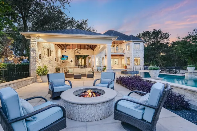 a view of a patio with couches and table and chairs with wooden fence and plants