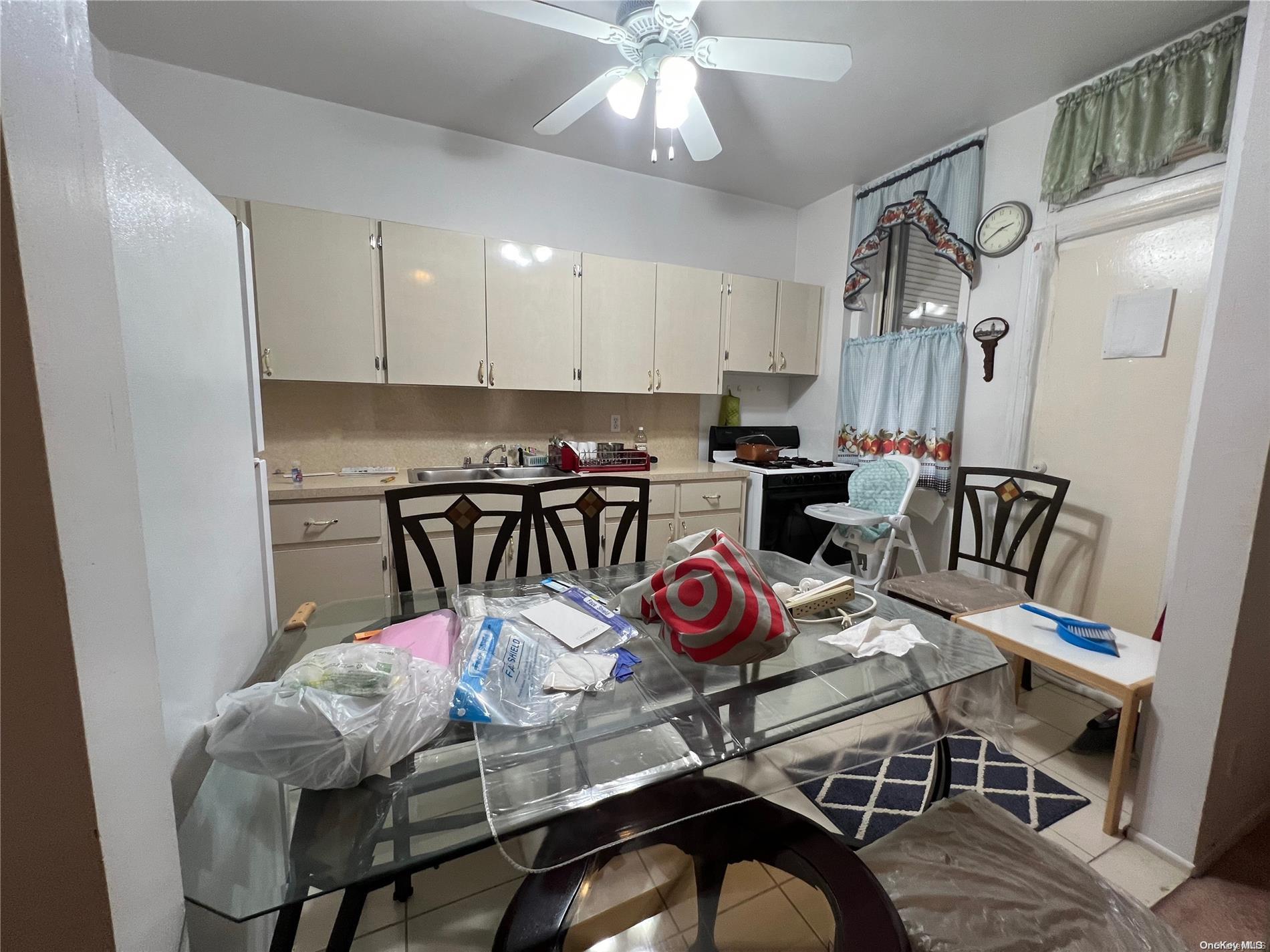368 Eldert Lane Brooklyn, NY 11208 - Photo 3 of 10 a kitchen with stainless steel appliances granite countertop a dining table chairs and white cabinets