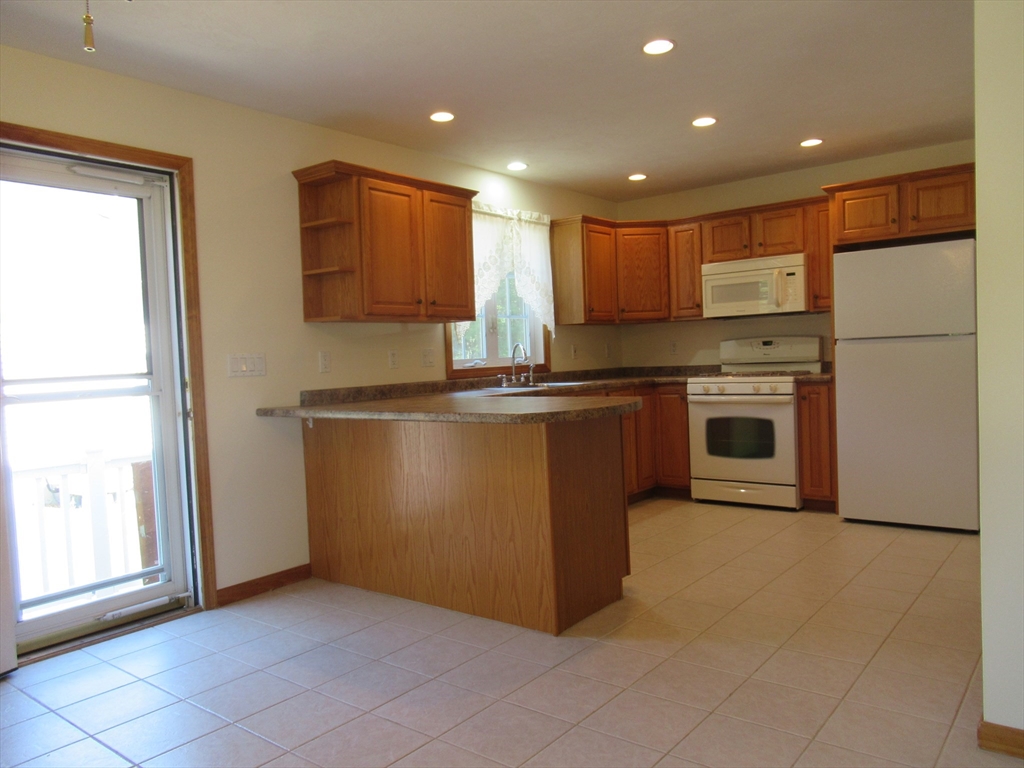 25 Rodeo Drive East Bridgewater, MA 02333 - Photo 4 of 17 a kitchen with stainless steel appliances granite countertop a refrigerator a sink a stove and a refrigerator with wooden cabinets