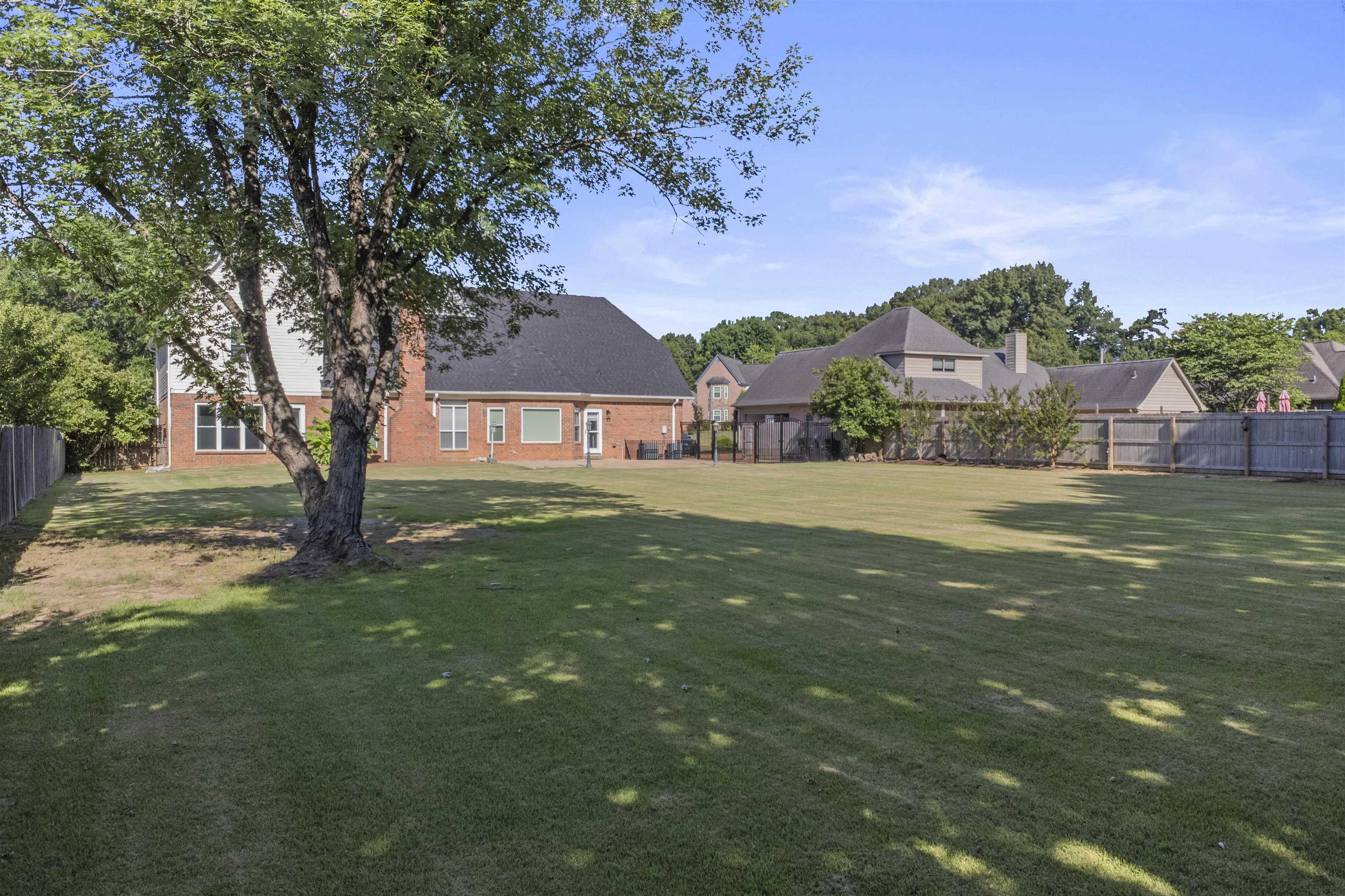 4279 High Plains Road Bartlett, TN 38135 - Photo 6 of 37 Expansive backyard featuring a manicured lawn, mature trees, and privacy fencing