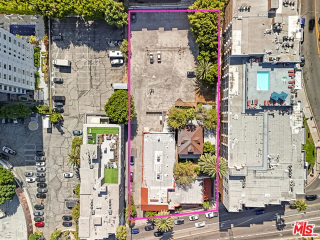 aerial view of multi story residential apartment building with yard