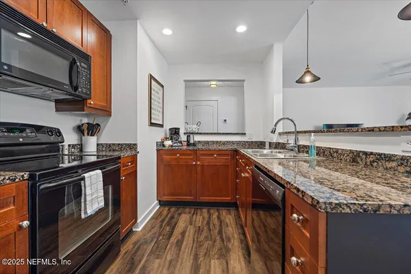 a kitchen with stainless steel appliances granite countertop a stove a sink and a microwave