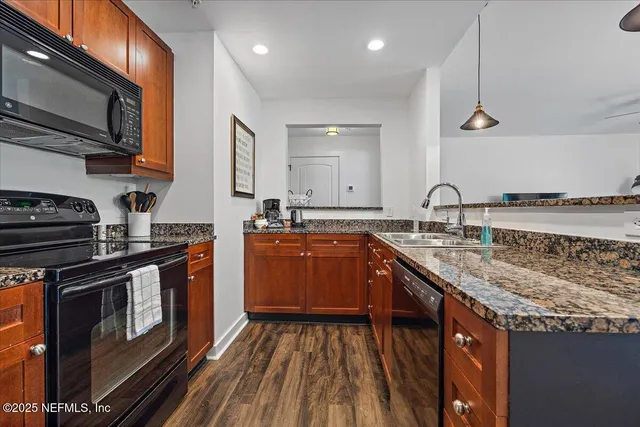 a kitchen with stainless steel appliances granite countertop a stove a sink and a microwave