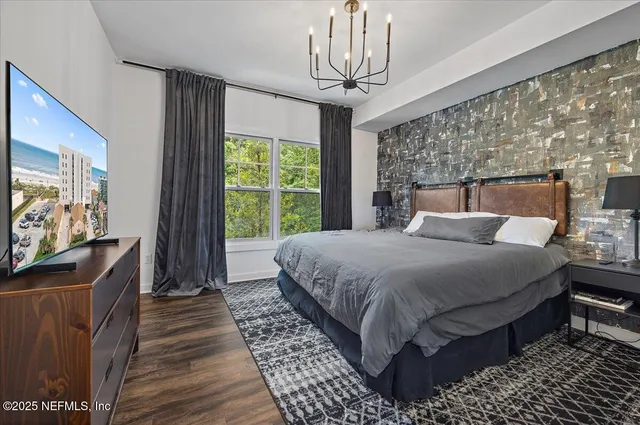 a bedroom with a bed and a flat tv screen on dresser