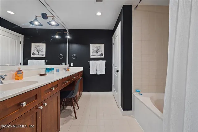 a spacious bathroom with a tub sink and mirror
