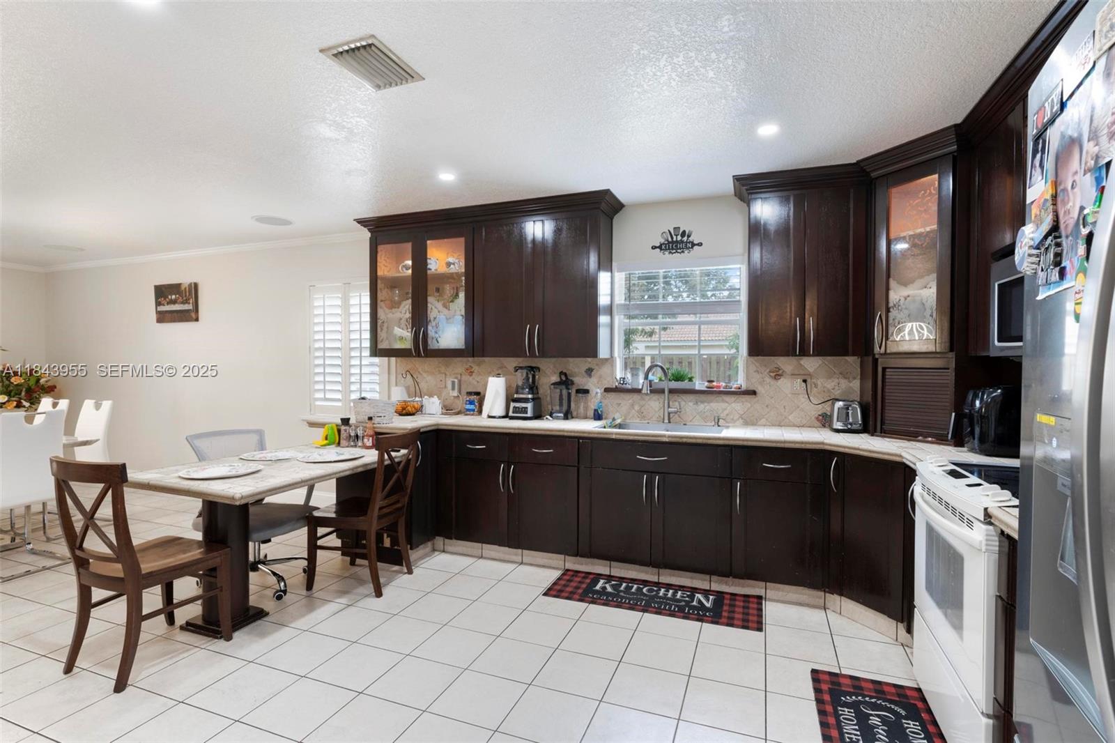 28401 Southwest 158th Court Homestead, FL 33033 - Photo 11 of 47 a kitchen with a sink dining table and chairs