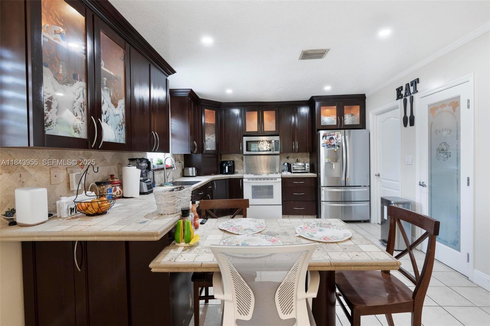 28401 Southwest 158th Court Homestead, FL 33033 - Photo 10 of 47 a kitchen with sink a refrigerator and chairs