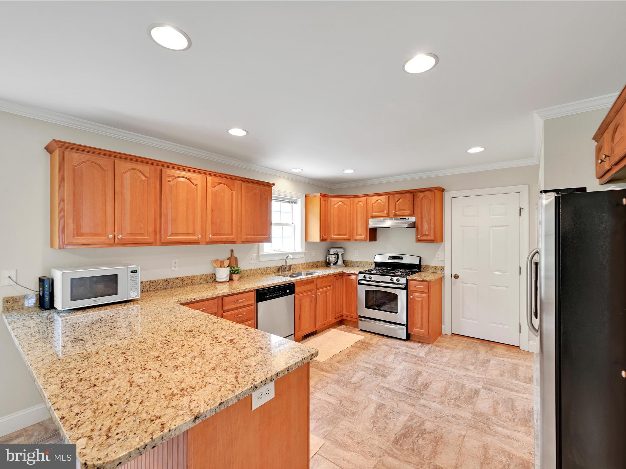 7 West Ridge Road Lititz, PA 17543 - Photo 10 of 40 a kitchen with stainless steel appliances granite countertop a stove top oven a sink dishwasher and a refrigerator with wooden floor