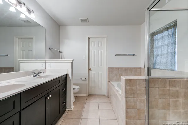 a spacious bathroom with a granite countertop sink a toilet a mirror and vanity