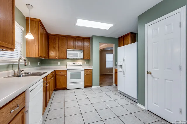 a kitchen with a sink a counter top space cabinets and stainless steel appliances