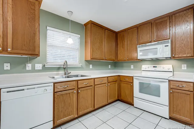 a kitchen with cabinets appliances a sink and a window