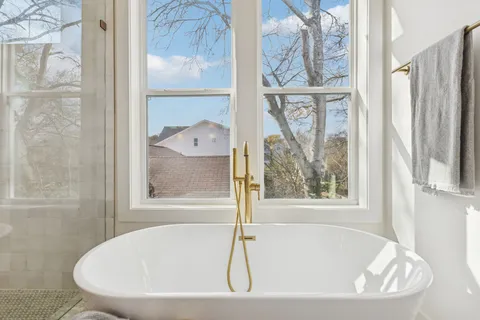 a white bath tub sitting next to a window