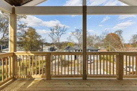 a view of a balcony with wooden floor & fence