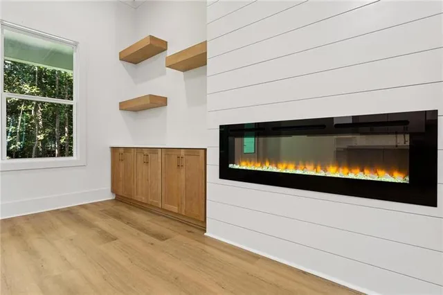 a kitchen with stainless steel appliances granite countertop a sink dishwasher a stove and white cabinets with wooden floor