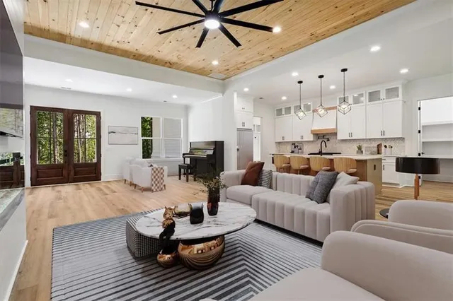 a living room with furniture kitchen view and a large window