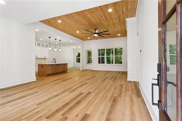 a view of an empty room with a window and wooden floor