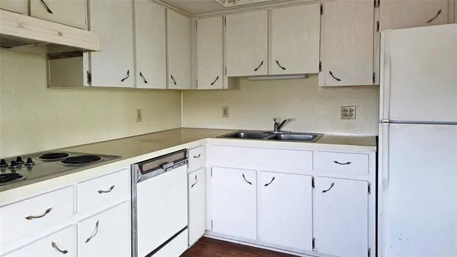 a kitchen with white cabinets and white appliances