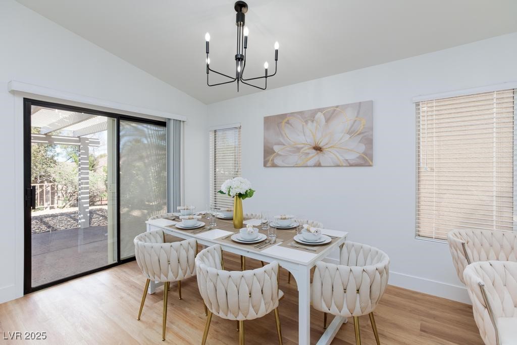502 Edgefield Ridge Place Henderson, NV 89012 - Photo 11 of 38 Dining area featuring a chandelier, vaulted ceiling, light wood finished floors, and baseboards
