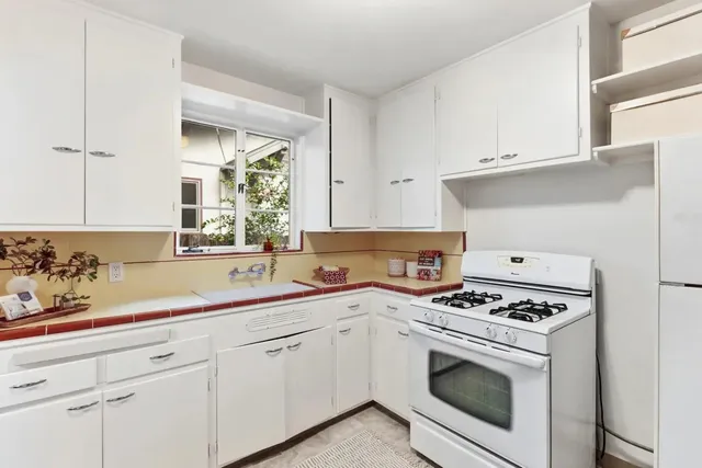 a kitchen with cabinets appliances a sink and a window