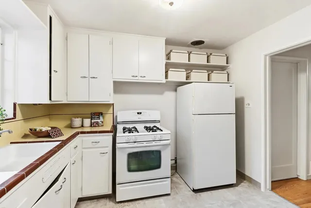 a kitchen with a refrigerator stove and white cabinets