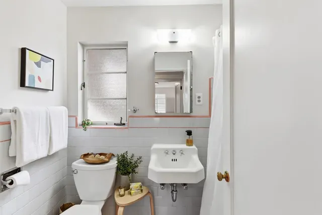 a bathroom with a sink a toilet and a mirror