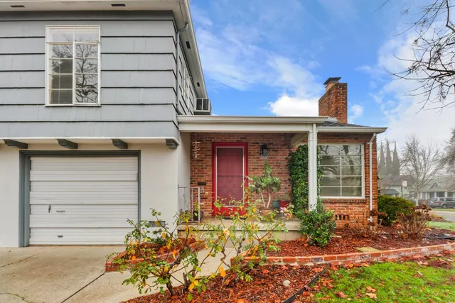 a view of a backyard with plants and brick wall