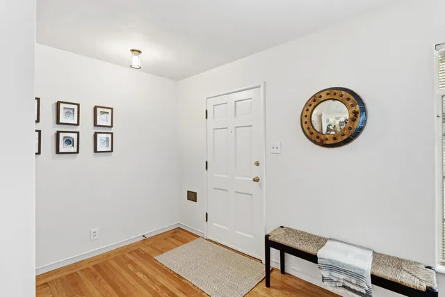 a view of a room with wooden floor and small workspace