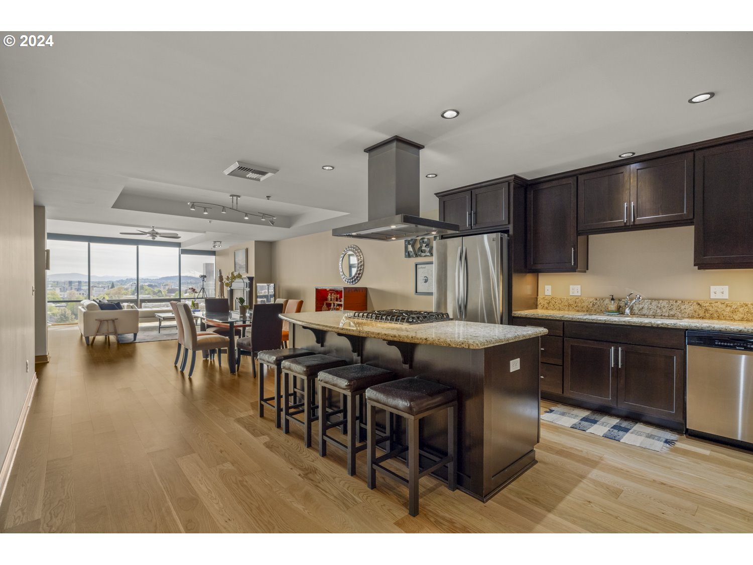 2454 Northwest Westover Road, Unit 405 Portland, OR 97210 - Photo 7 of 37 a kitchen with stainless steel appliances granite countertop a table chairs sink and cabinets