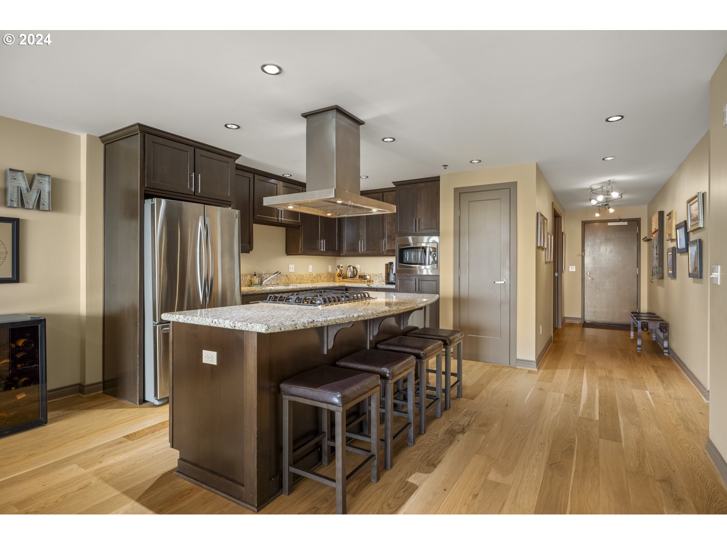 2454 Northwest Westover Road, Unit 405 Portland, OR 97210 - Photo 8 of 37 a kitchen with kitchen island a refrigerator stove and wooden floor
