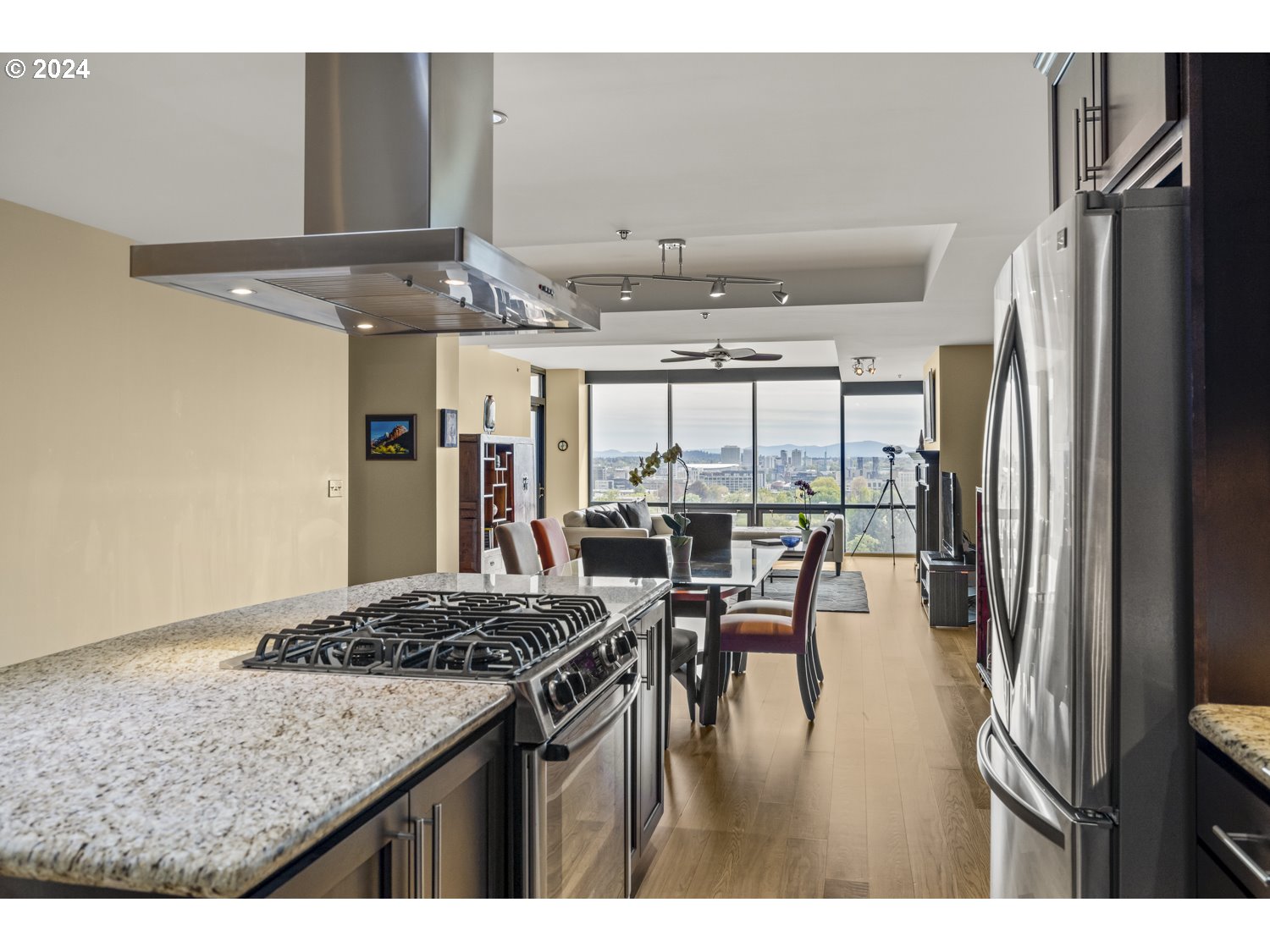 2454 Northwest Westover Road, Unit 405 Portland, OR 97210 - Photo 10 of 37 a kitchen with stainless steel appliances granite countertop a table chairs and a refrigerator