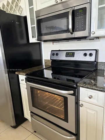 a stove top oven sitting inside of a kitchen with stainless steel appliances wooden cabinets and a stove top oven