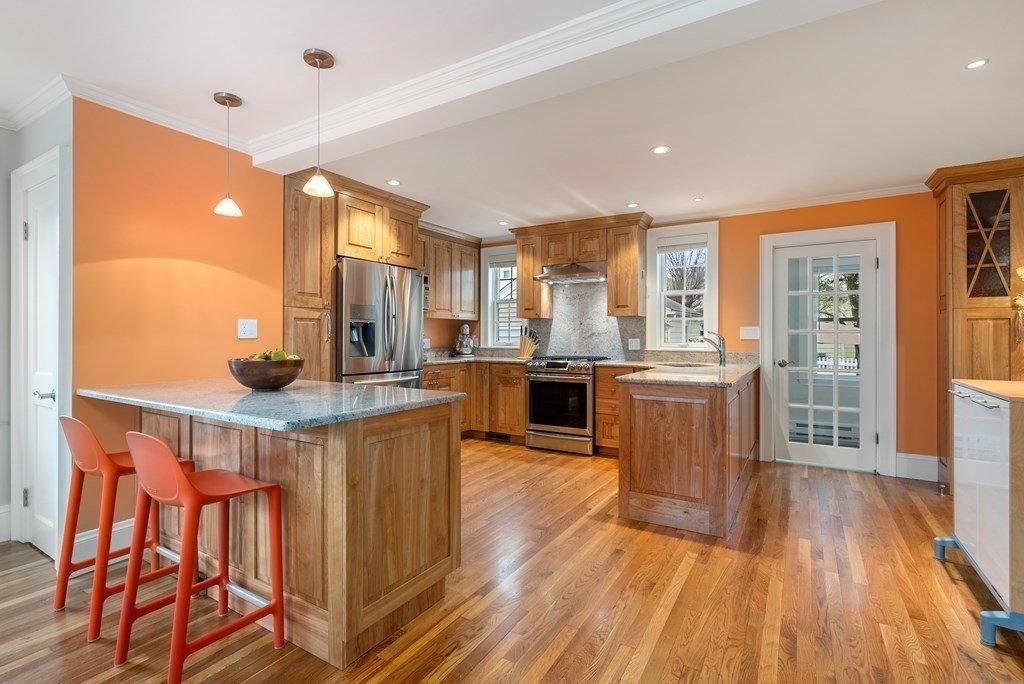 54 Merrill Road Watertown, MA 02472 - Photo 13 of 36 a kitchen with stainless steel appliances kitchen island granite countertop wooden floors and a view of living room