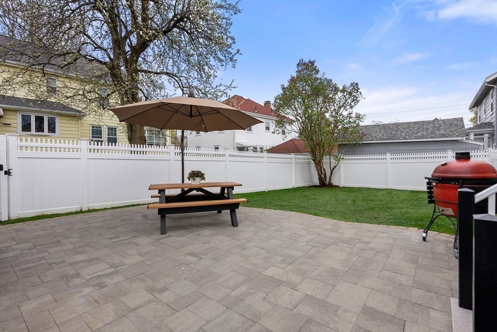 54 Merrill Road Watertown, MA 02472 - Photo 33 of 36 a view of a yard with a bench and a fire pit