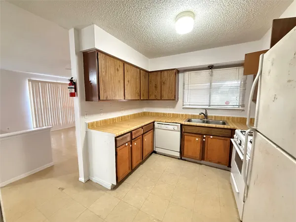 a kitchen with granite countertop a sink stove and refrigerator