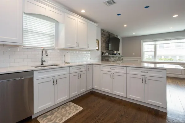 a kitchen with kitchen island white cabinets and appliances