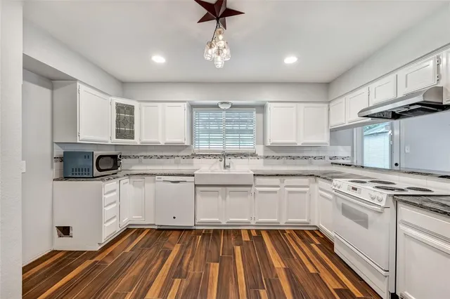 a kitchen with cabinets appliances a sink and a window