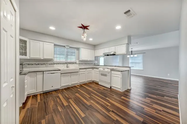 a kitchen with a white cabinets counter top space stainless steel appliances and a window