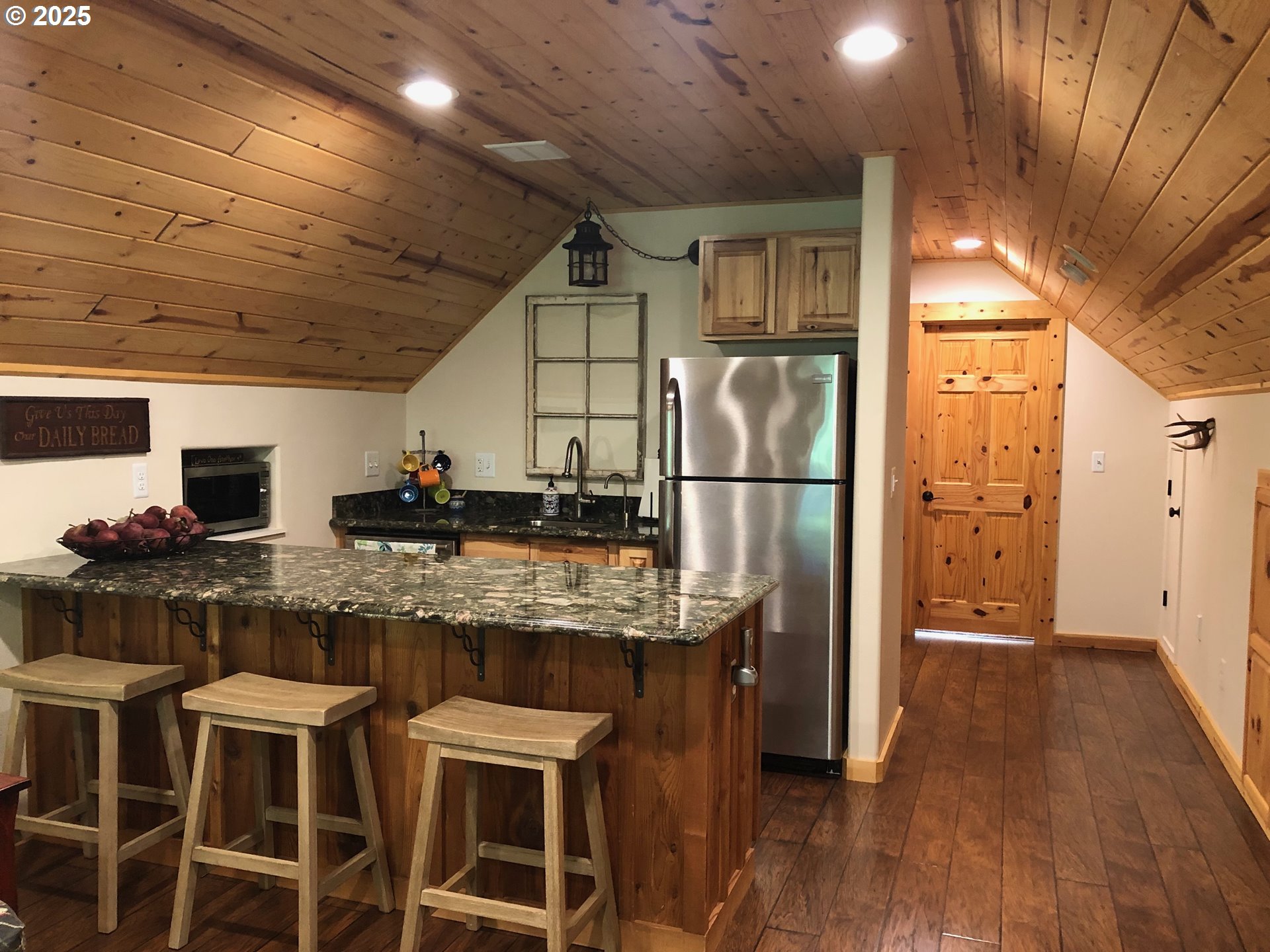 62941 Northwest Cochran Road Timber, OR 97144 - Photo 23 of 44 a kitchen with stainless steel appliances granite countertop a table chairs refrigerator and a sink