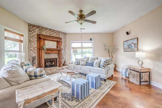 a living room with furniture a large window and a chandelier