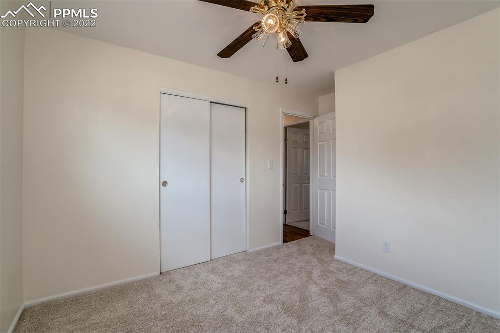 2515 Monterey Road Colorado Springs, CO 80910 - Photo 16 of 32 an empty room with a chandelier fan and a ceiling fan