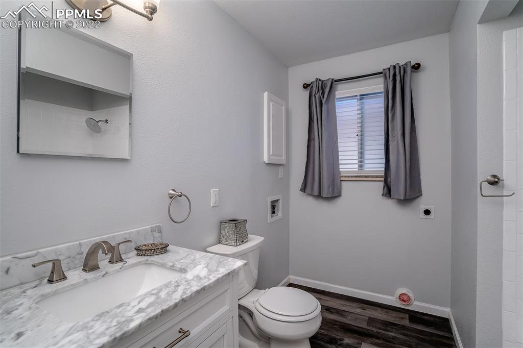 2515 Monterey Road Colorado Springs, CO 80910 - Photo 24 of 32 a bathroom with a granite countertop sink mirror vanity and toilet
