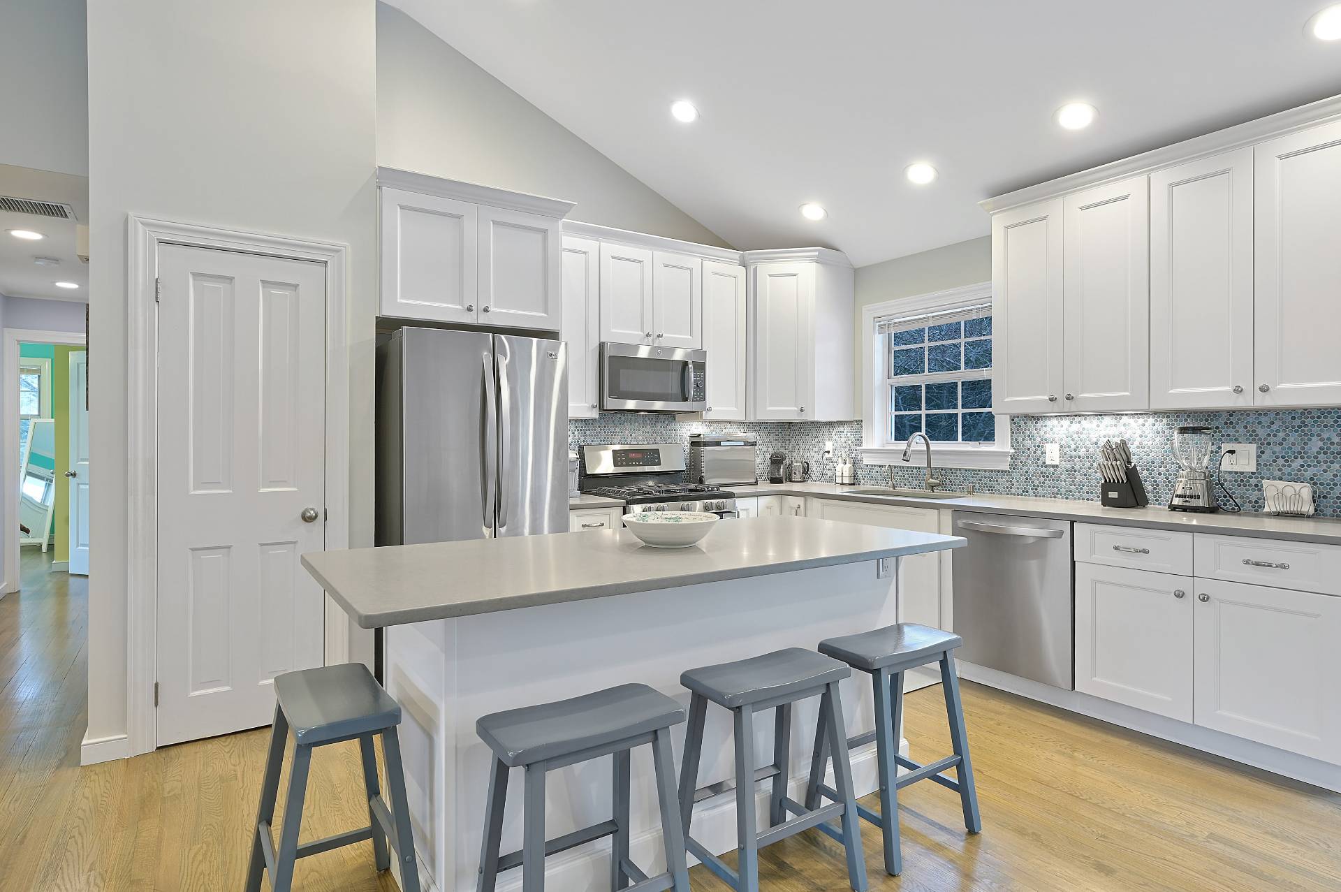 25 Nidzyn Avenue Remsenburg, NY 11960 - Photo 10 of 32 a kitchen with stainless steel appliances granite countertop a stove a sink a microwave a refrigerator and white cabinets with wooden floor